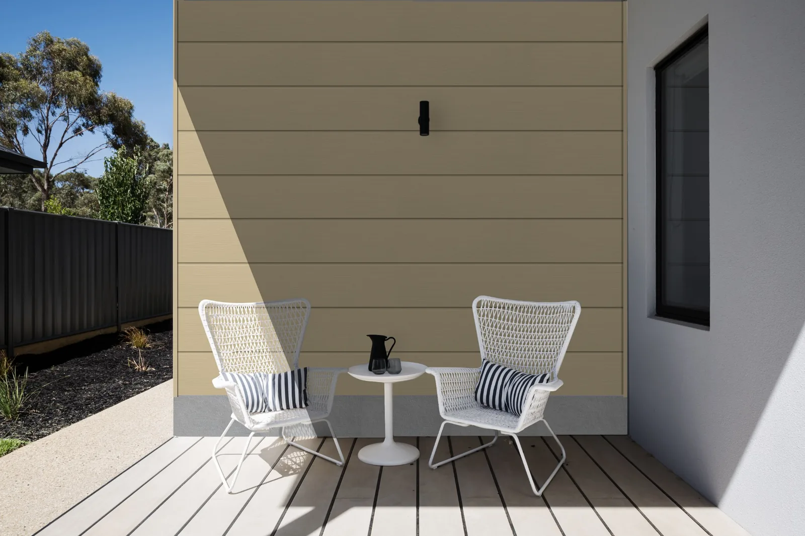 Fortex Clic horizontal cappuccino cladding used on a modern patio wall with outdoor chairs